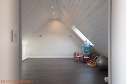 Vue d'ensemble des combles, lambris blanc, parquet sombre